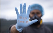 dłoń w rękawiczce z napisem Stop Covid-19