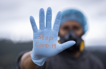 dłoń w rękawiczce z napisem Stop Covid-19